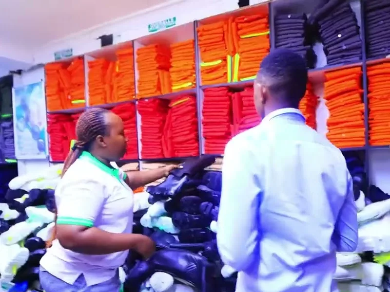 Safety Hub staff helping a customer at shelves of workwear and safety boots in the Nairobi shop